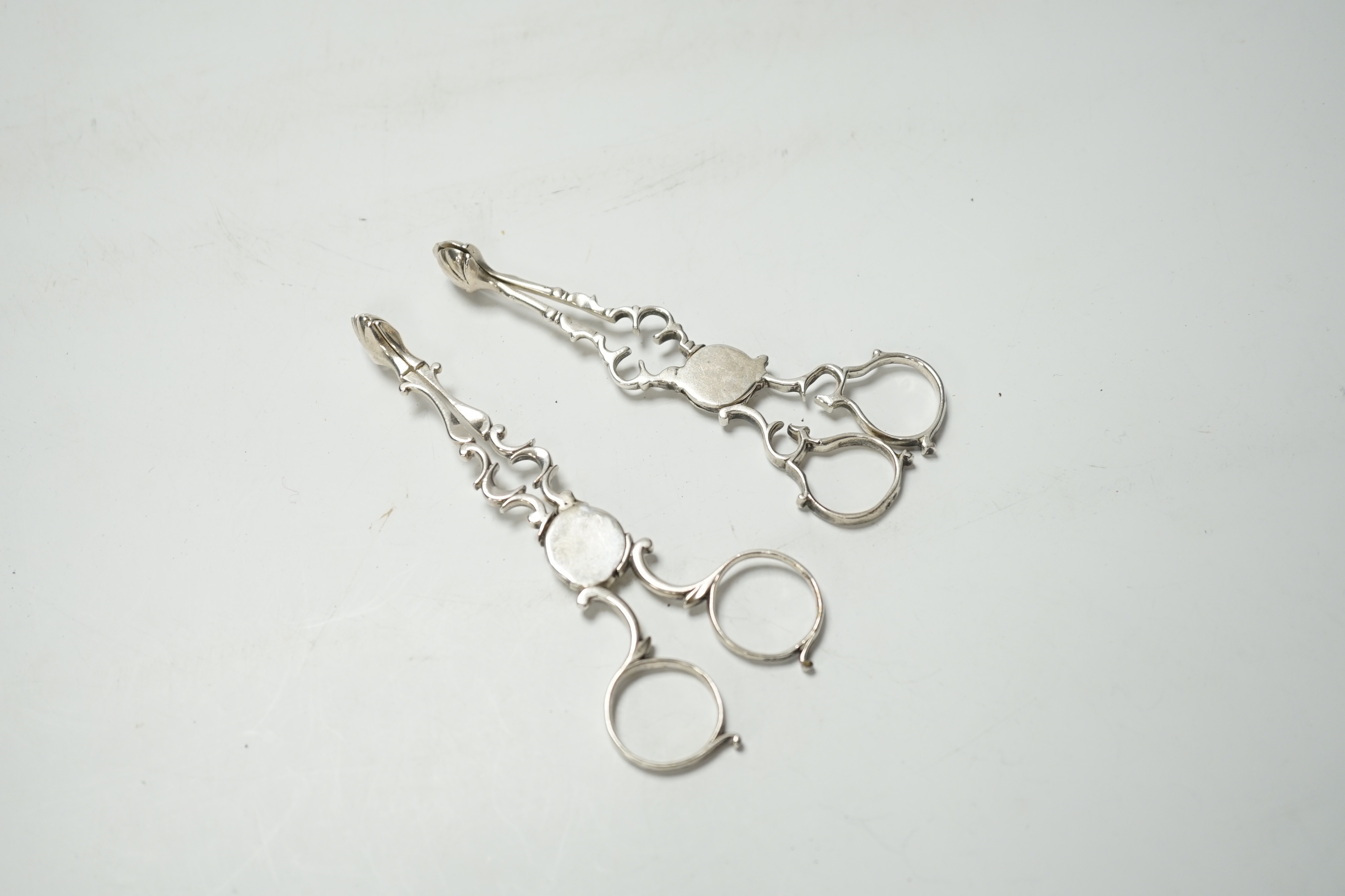 A pair of mid 18th century silver sugar nips, 12.3 cm and a pair of George V silver sugar nips.